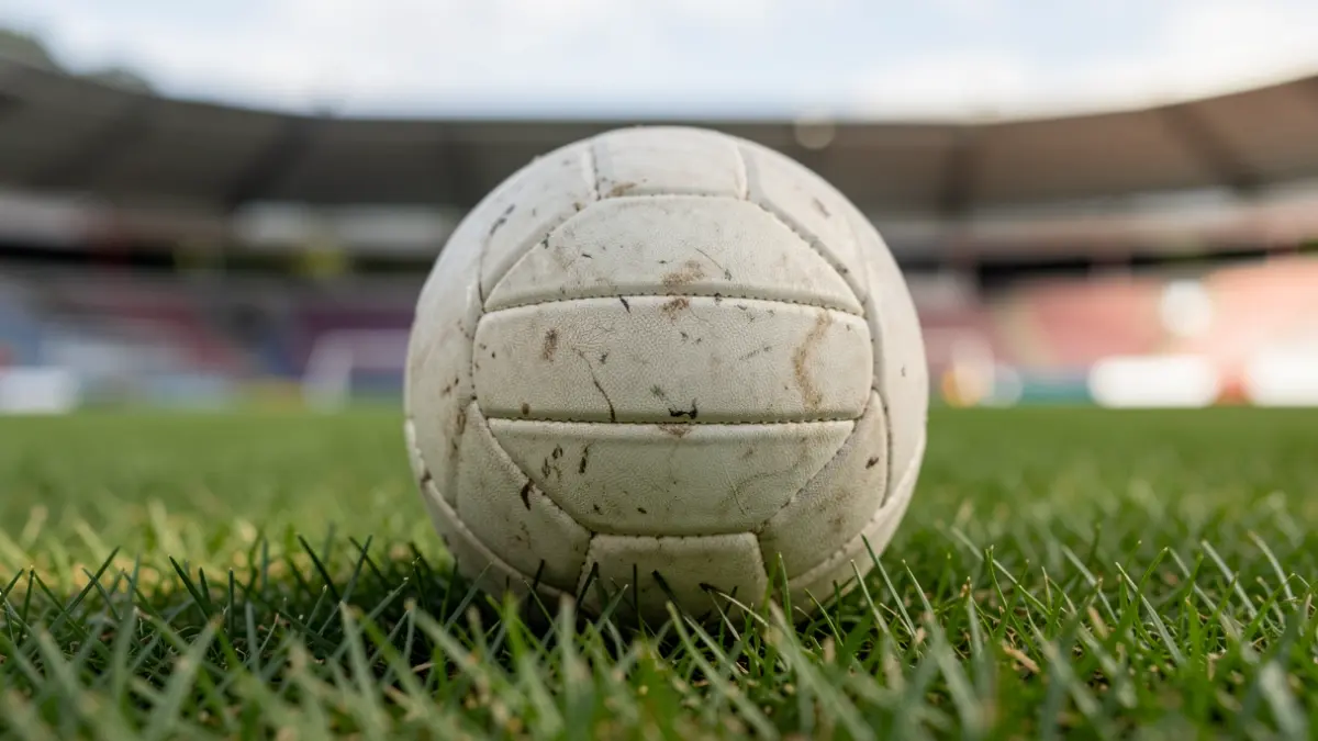 Image générique d'un ballon de netball sur de l'herbe, avec un stade flou en arrière-plan.
