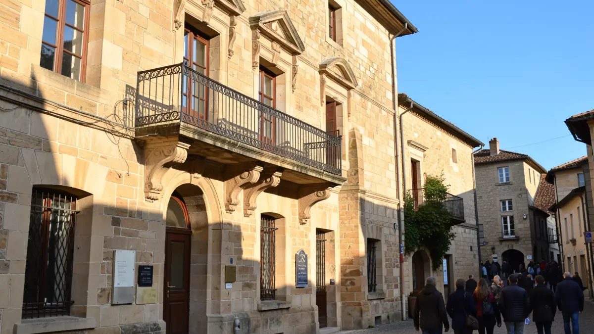 Generic image of a stone town hall facade with an ornate balcony, under an afternoon sun.